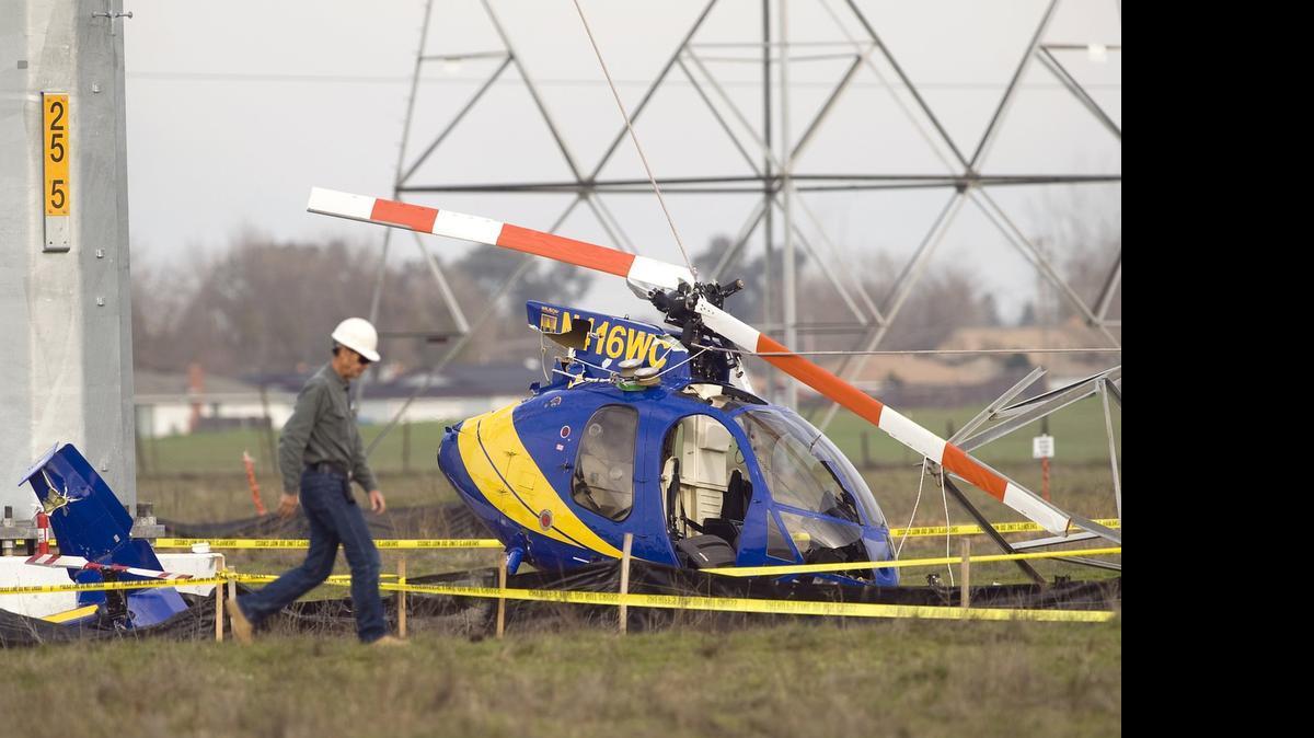 
A worker with the U.S. Dept. of Energy walks past the debris of a helicopter that went down in a field off of West Elverta Road in North Sacramento in February, 2011, while doing work under contract for the Sacramento Metropolitan Utility District and the Western Power Authority at a site where power lines and towers were being taken down and replaced. Utility and transportation workers have the state’s highest employer-paid workers’ compensation insurance premiums.
