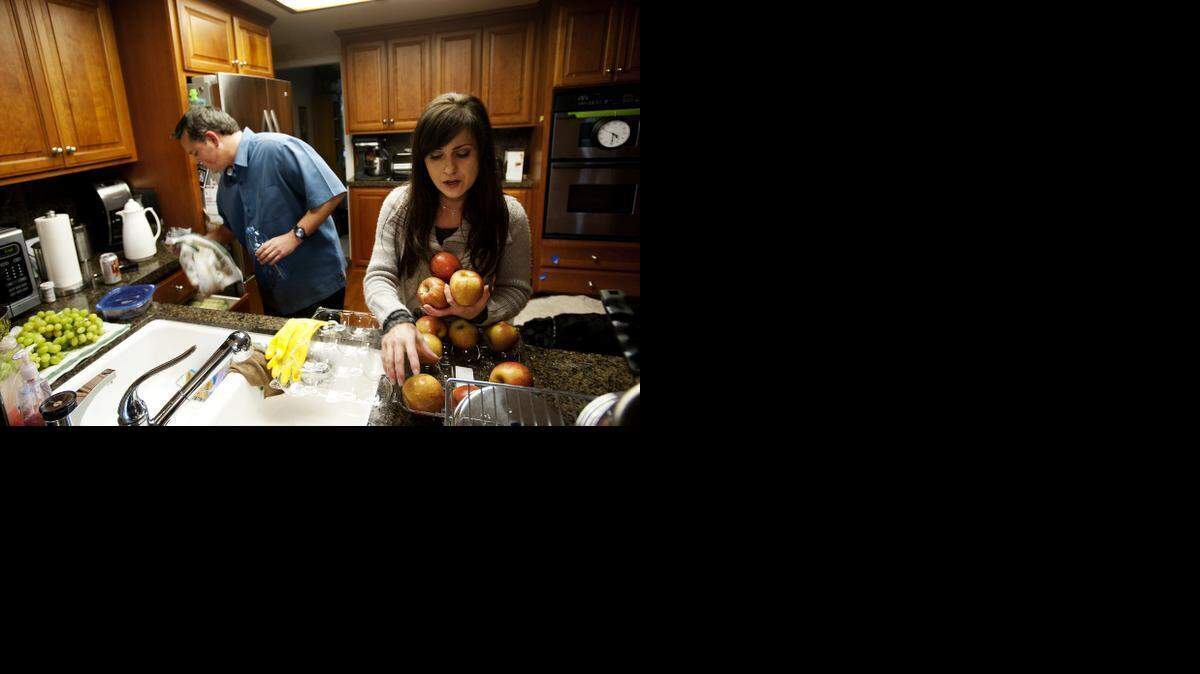 
April Garr cleans apples after returning from the store. She and her husband Brian Garr, left, used food stamps to supplement their income in 2010 after Brian lost his job as a mechanical engineer in Rancho Cordova after his employer moved operations to Southern California.
