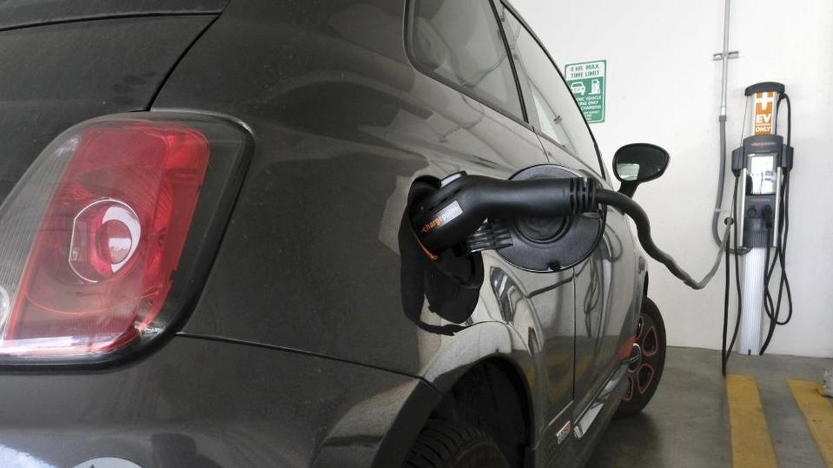 An electric Fiat plugged into a charging station in a parking lot in Los Angeles.