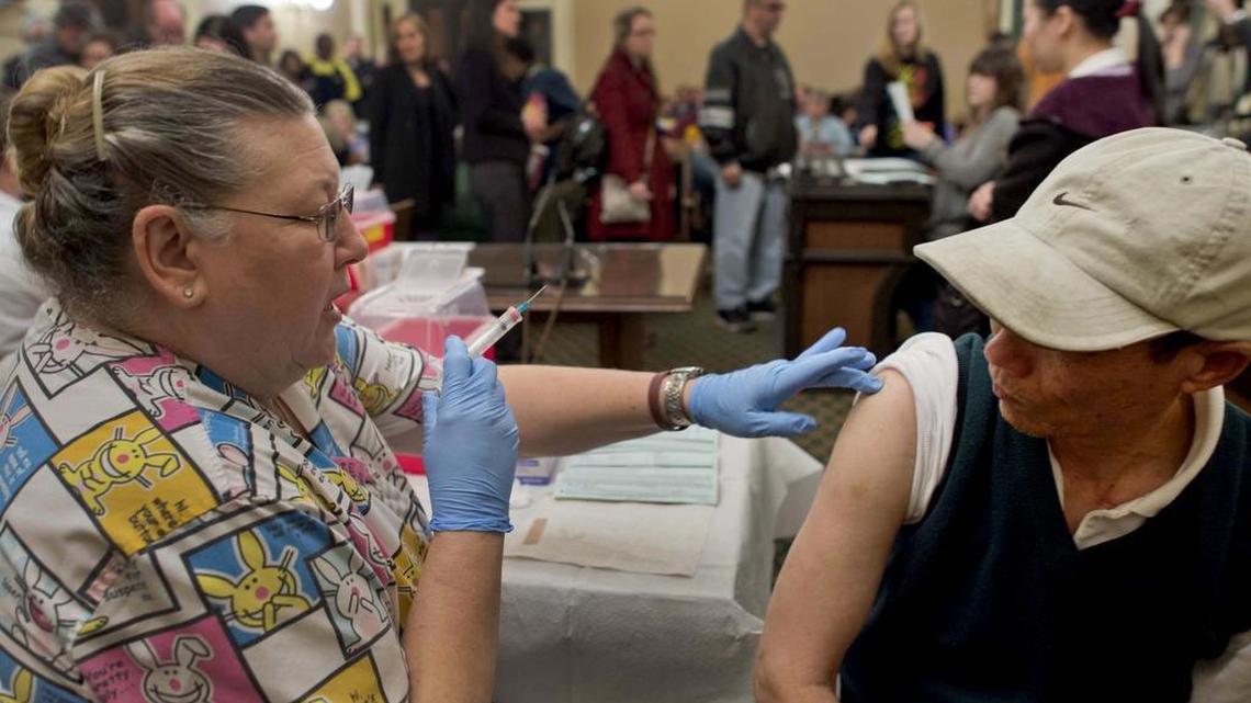 
Licensed vocational nurse Geneva Hill, readies a flu shot for Zhuo Fen Huang of Sacramento at the Capitol in 2013. Anthem Blue Cross, one of the largest managed-care organizations in California, arranged for the shots.
