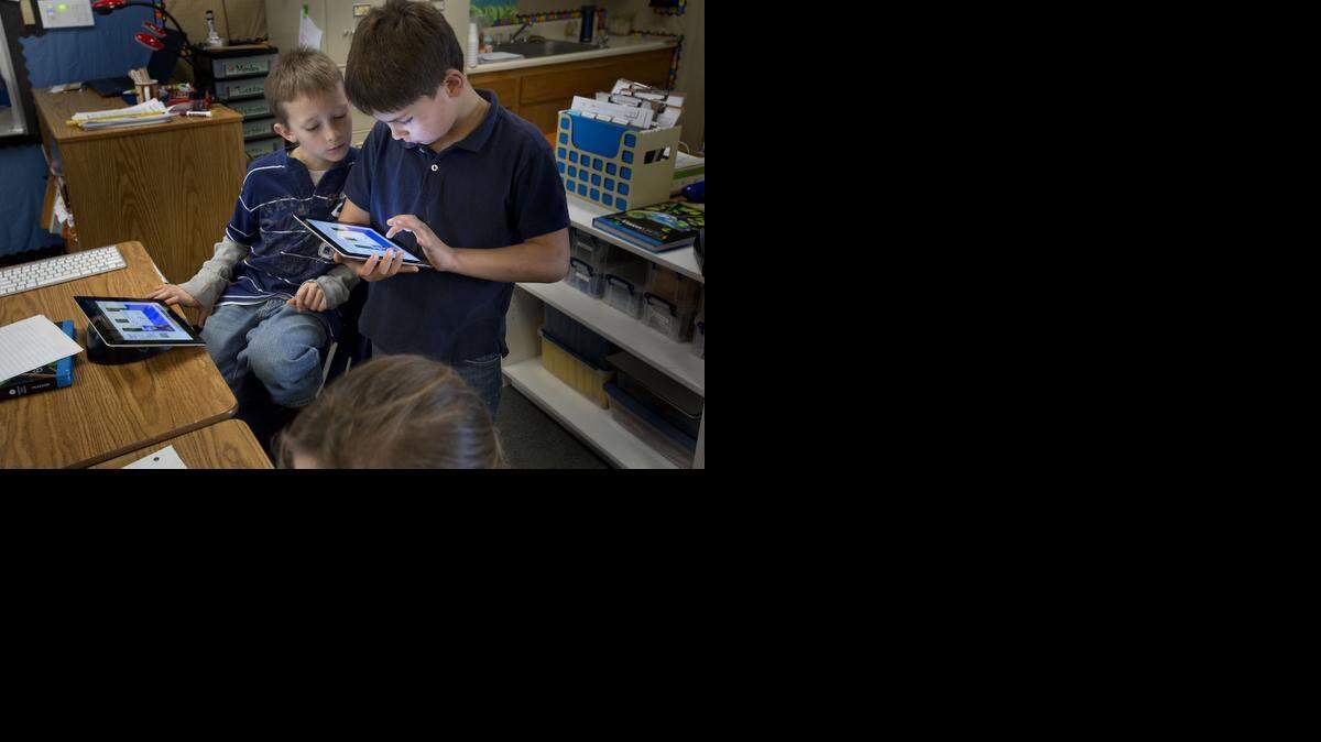 
Wyatt Blevins 10, left, and Mason Meza 9, use iPads connected to the Internet in the classroom at Sheridan Elementary School in Sheridan on Wednesday. 
