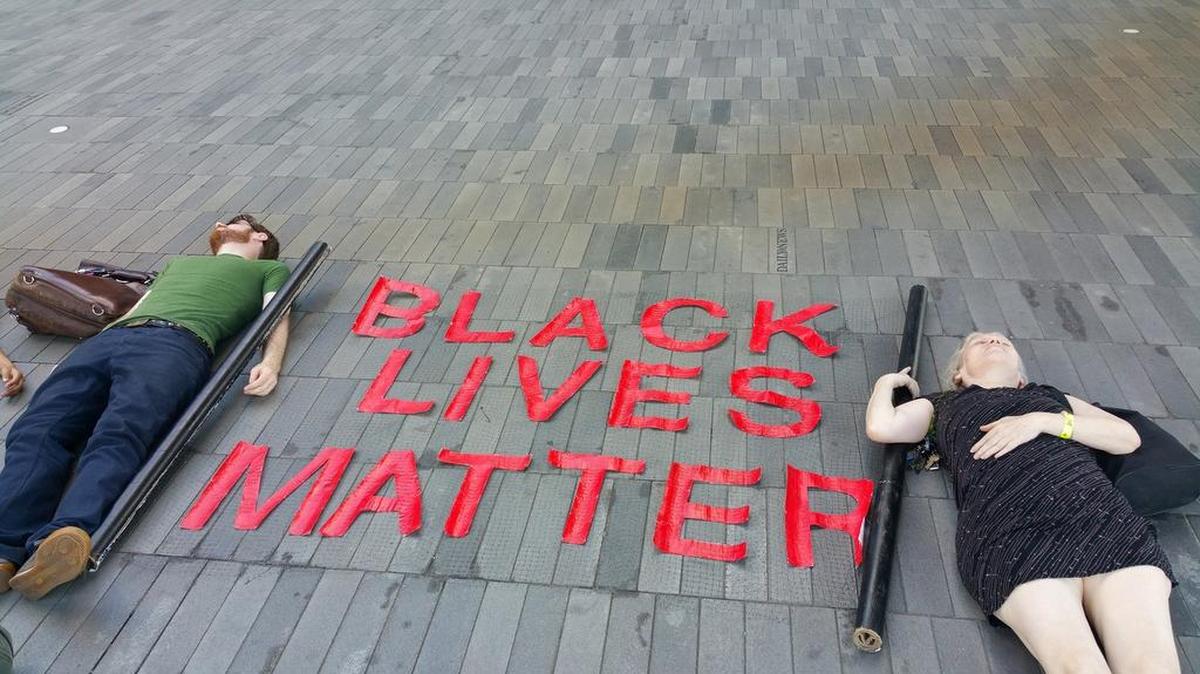 
Two protestors lay motionless on the pavement outside of Brooklyn's Barclays Center, marking the one-year anniversary of the shooting death of Michael Brown, Sunday, Aug 9, 2015, in New York.
