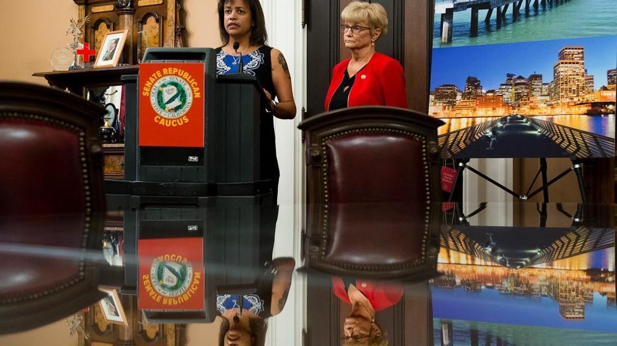 
Susan Oliver, widow of Sacramento County sheriff’s Deputy Danny Oliver, speaks Thursday at the Capitol in support of a bill introduced by Sen. Sharon Runner, R-Lancaster, right, aimed at preventing undocumented immigrant felons from evading custody to commit more crimes.

