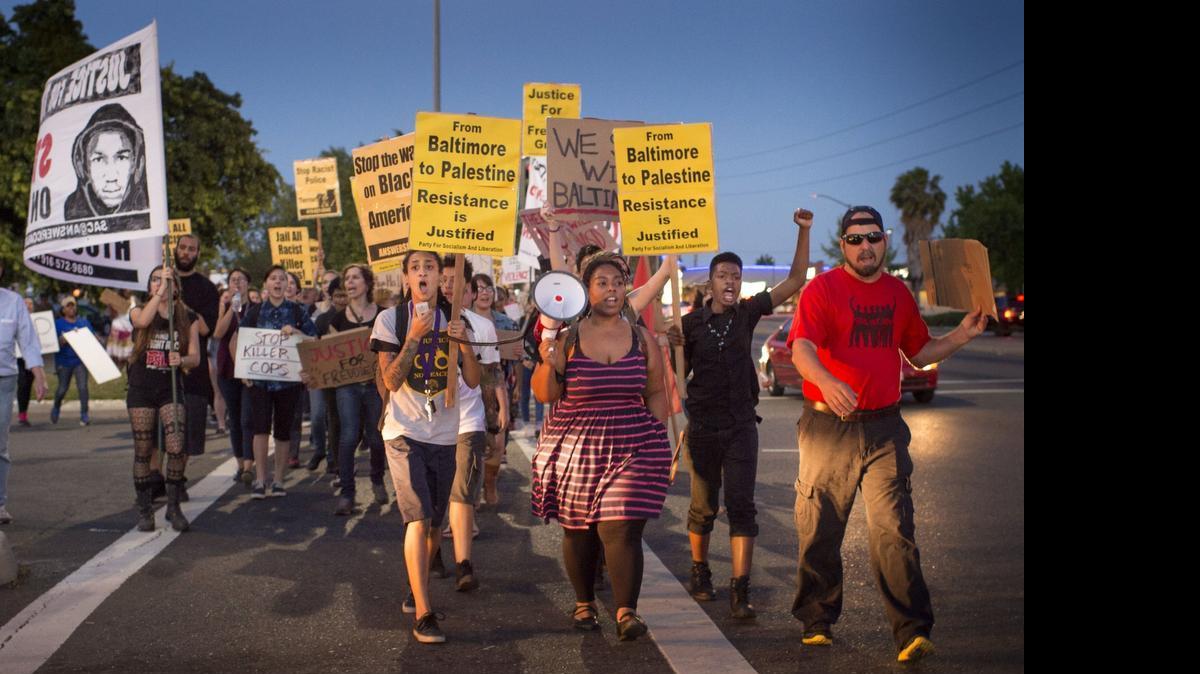 
Maile Hampton, center left, leads a protest march in April. At another rally, she was accused of interfering with an arrest and violating a law that used the word “lynching.” 
