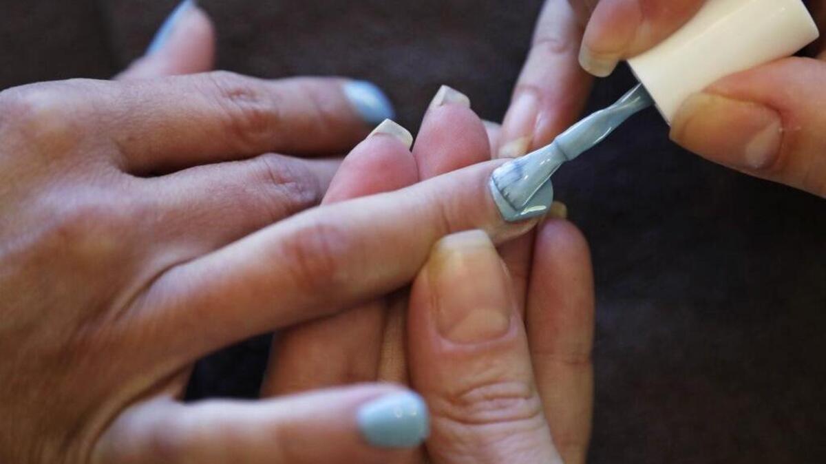In this Tuesday, Aug. 23, 2016, photo, Christine Perkins, right, who owns Pyara Spa and Salons at two locations in the Boston area, applies nail polish for a client at her salon in Burlington, Mass.