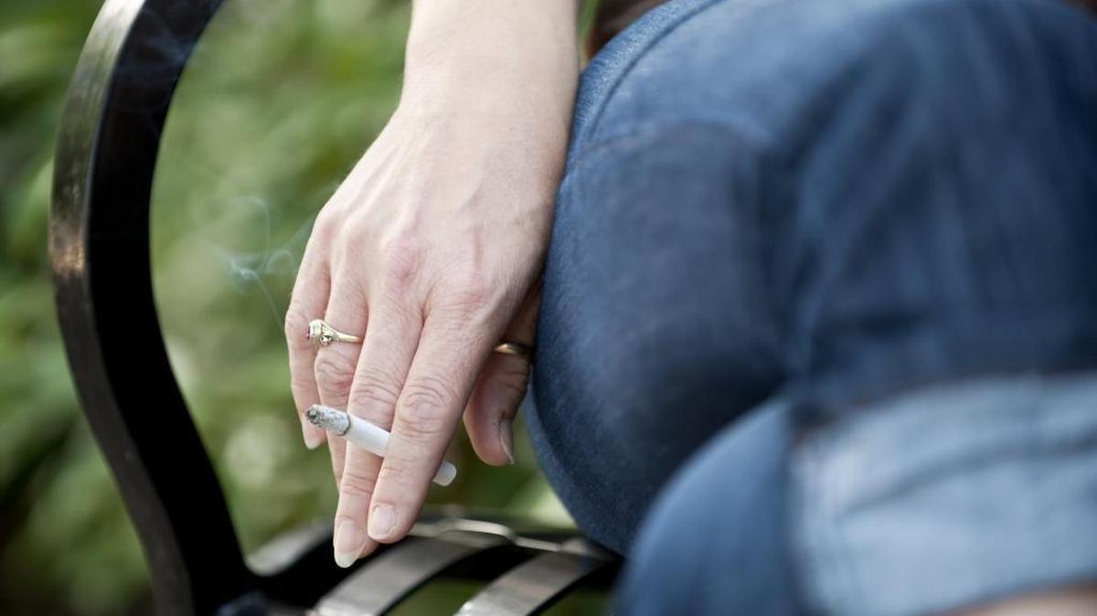A woman smokes a cigarette on her lunch break outside the Department of Justice in Sacramento on Wednesday, June 23, 2010.
