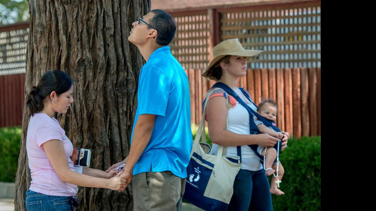 
David Chavez, 29, and his wife Jackelin Aguilar, left, 26, pray alongside Amelia Ruiz, 25, and her son Avel Ruiz, 2 months old, after joining anti abortion-rights protesters at Planned Parenthood in Sacramento in July.
