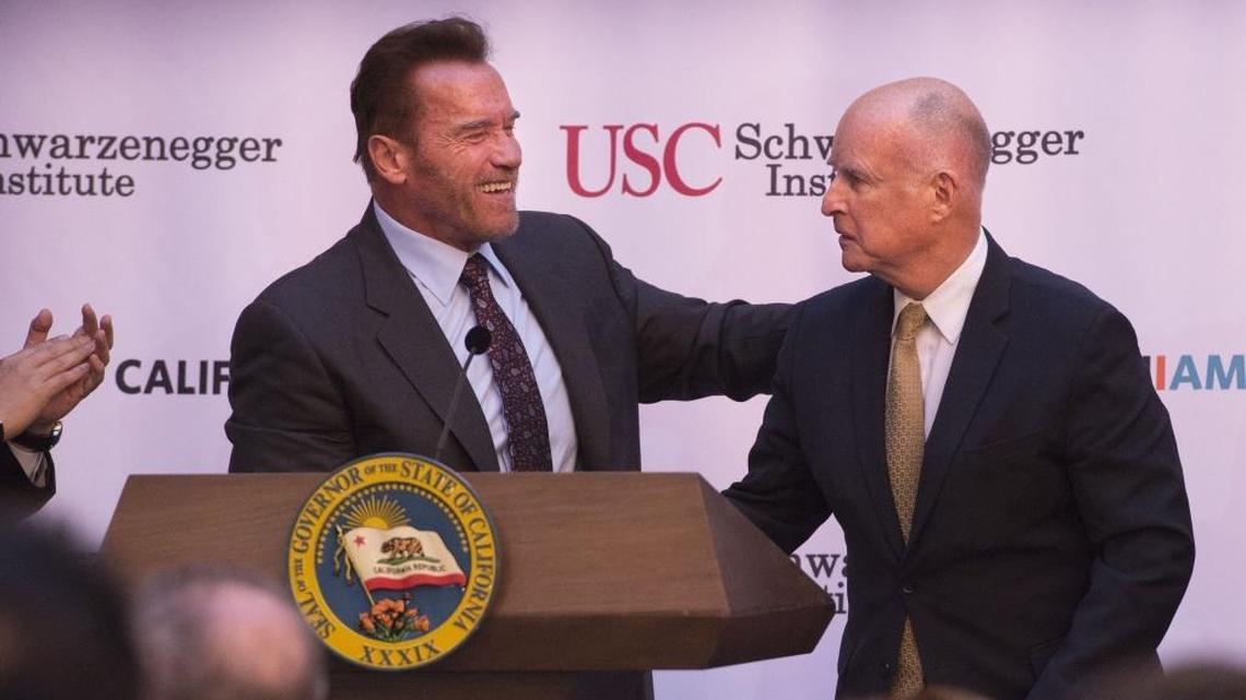 Former Gov. Arnold Schwarzenegger shakes hands with Gov. Jerry Brown as they celebrate the 10th anniversary celebration of AB 32 signing on Oct. 5, 2016.