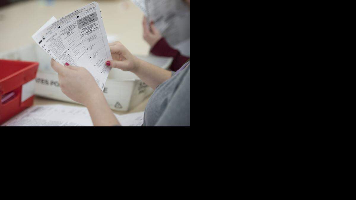 
Kaitlin Hubber, an election clerk, looks at an absentee ballot at the Sacramento County Registrar of Voters office in 2012.
