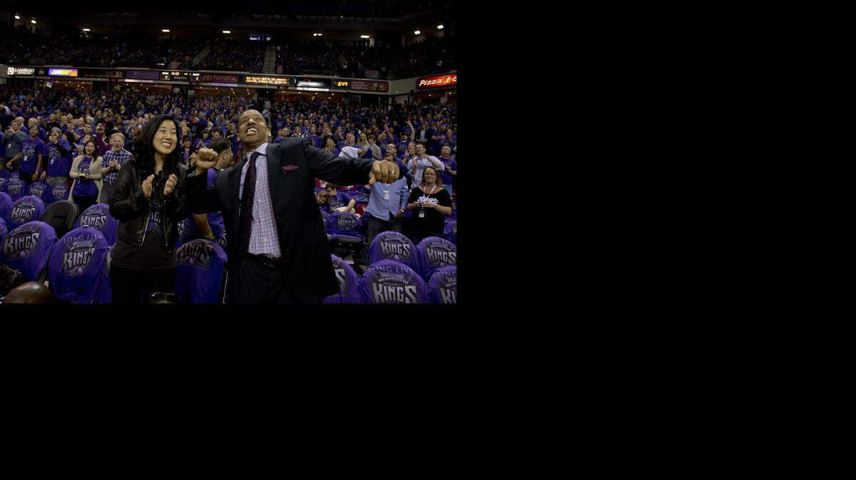 
Sacramento Mayor Kevin Johnson and wife Michelle Rhee respond to cheers from the crowd at the Sacramento Kings season opener on October 30, 2013.
