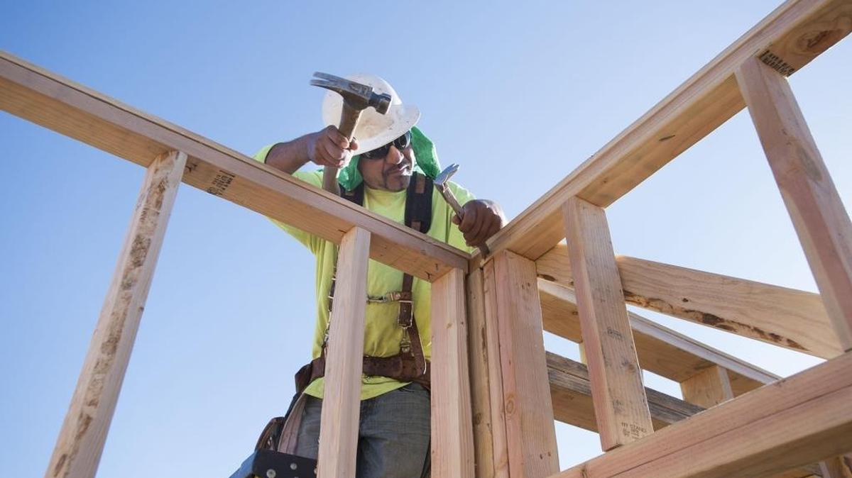 A construction worker works on framing on a home in North Natomas in July.