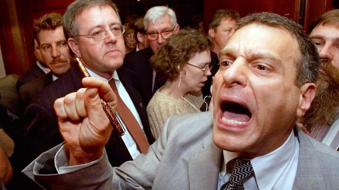 In this Aug. 8, 2000 file photo, Jim Mangia, right, the national secretary for the Reform Party, points as he leads a group of national committee members walking out of the party's credential committee meeting in Long Beach, Calif.