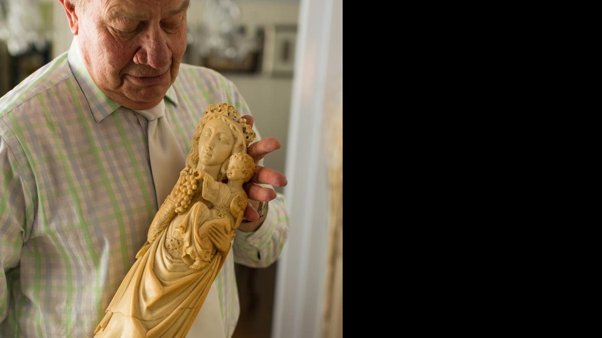 
Ivory collector Godfrey Harris holds The Madonna of the Grapes, a 19th century piece made from a 26-inch-long mature elephant tusk.
