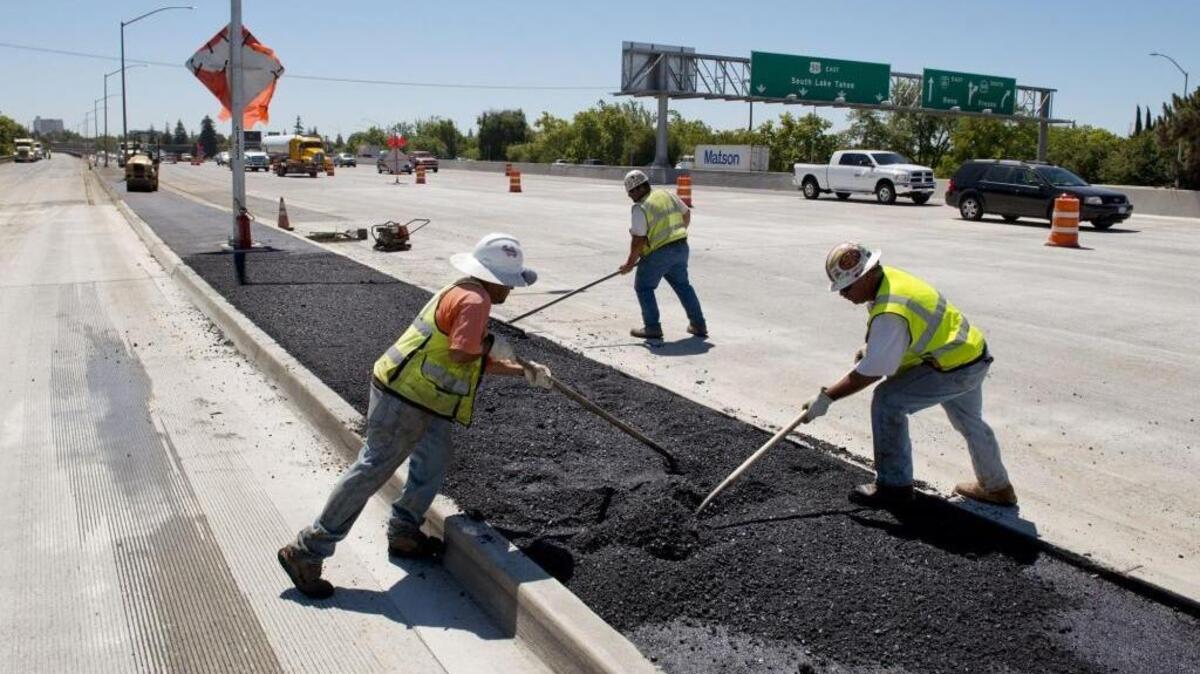 
Construction workers fix a freeway in Sacramento in June 2014.

