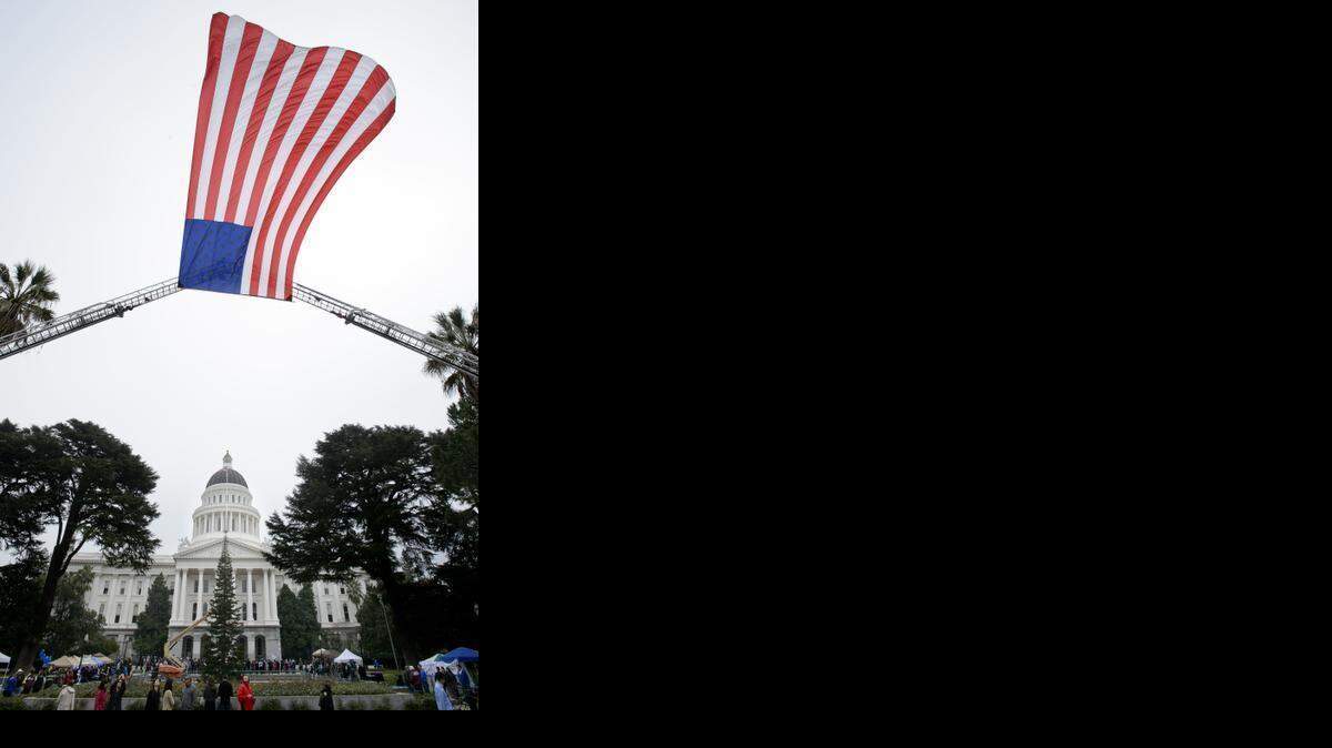 
The American flag hangs from Sacramento Fire Department aerial ladders during the Sacramento Rally to Support Law Officers at the Capitol Jan. 18.
