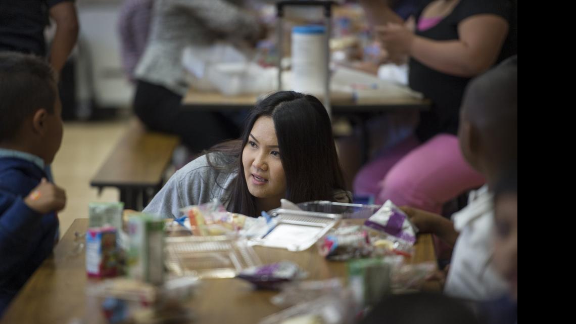 
Nancy Lee, STAR program manager at Tahoe Elementary School in Tahoe Park, talks with children over dinner on April 14 in Sacramento.
