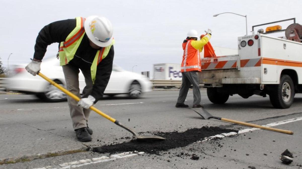 
Caltrans workers fill a pothole on the Capitol City Freeway with a cold asphalt patch, December 27, 2007.
