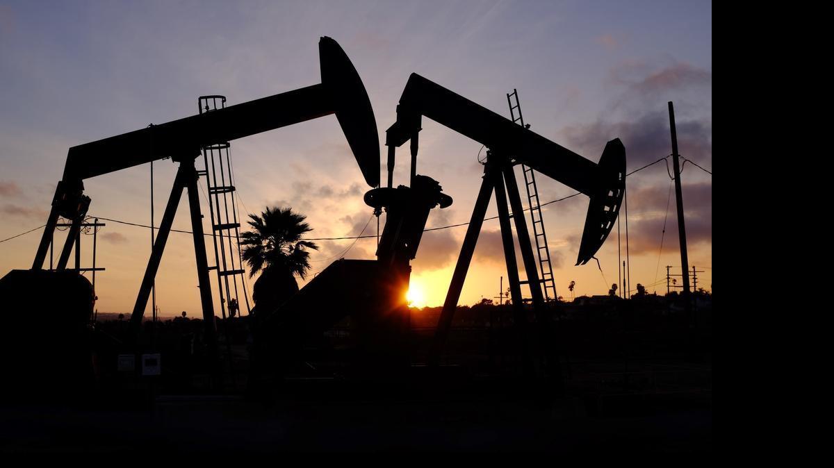 
The sun sets behind behind oil rigs operating at the Inglewood oil fields in the Baldwin Hills area of Los Angeles. 
