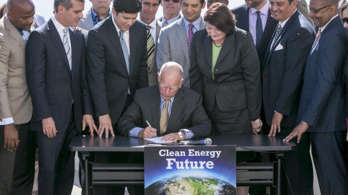 
California Gov. Jerry Brown, sitting center, surrounded by government officials, signs SB 350 at the Griffith Observatory in Los Angeles on Wednesday, Oct. 7, 2015.
