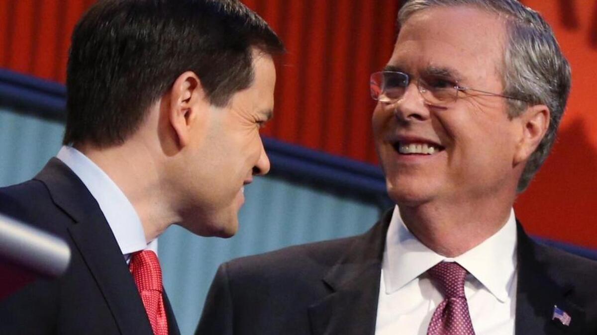 Republican presidential candidates Marco Rubio, left, and Jeb Bush talk during a break during the first Republican presidential debate at the Quicken Loans Arena in Cleveland.