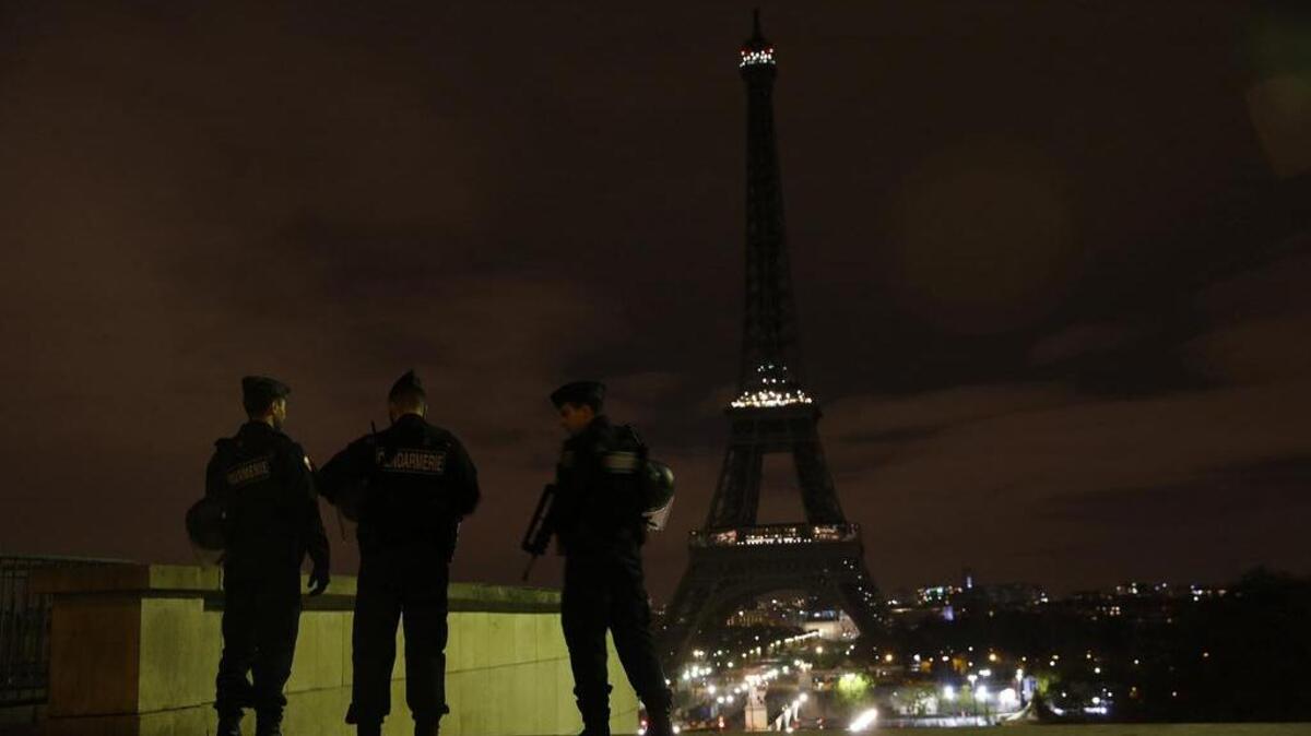 Armed police stand guard on Saturday, November 14, 2015, overlooking the Eiffel Tower, which was kept dark in honor of those who died in the terrorist attacks in Paris on Friday. France declares a national state of emergency after at least 120 people were killed in gun and bomb attacks. (Carolyn Cole/Los Angeles Times/TNS)