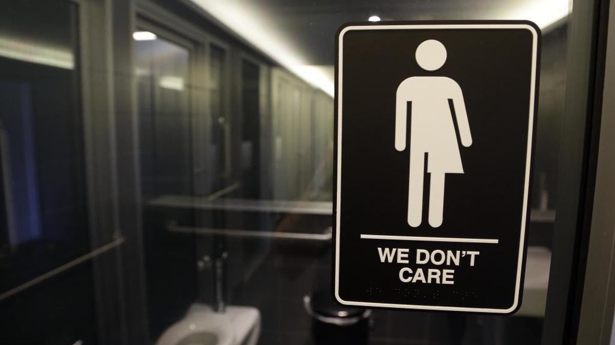 In this Thursday, May 12, 2016, file photo, signage is seen outside a restroom at 21c Museum Hotel in Durham, N.C. Ten states sued the federal government Friday, July 8, 2016, over rules requiring public schools to allow transgender students to use restrooms conforming to their gender identity, joining a dozen other states in the latest fight over LGBT rights.
