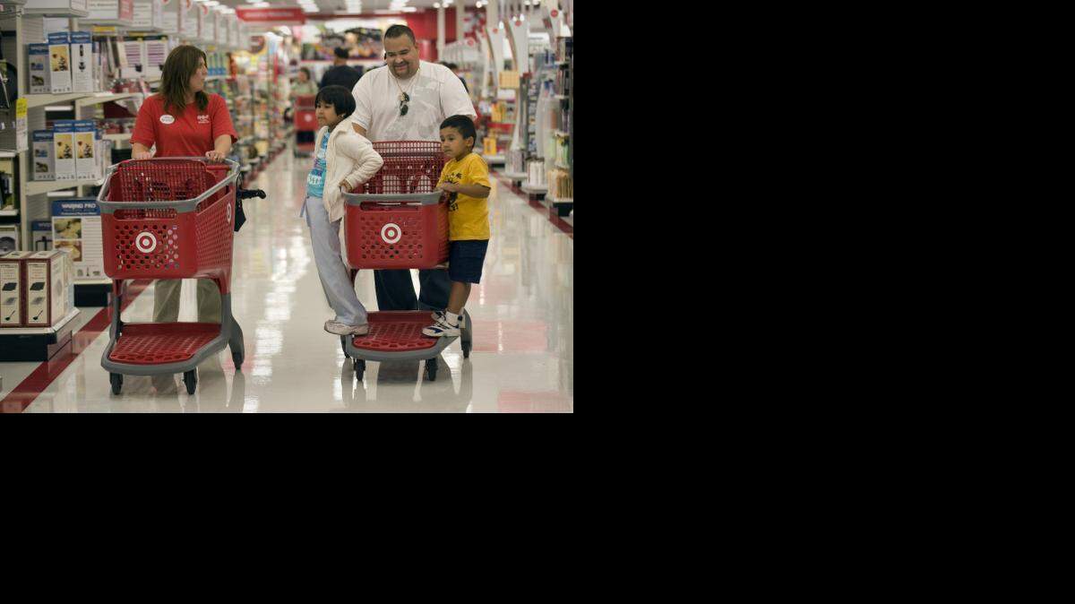 
Target employee Karen Miller talks to Richard Ortiz, 42, of West Sacramento while his children Brianda Ortiz, 7, left, and Diego Ortiz, 3, ride on the shopping cart. Ortiz (he was not working when the picture was taken in 2009) was later hired at the Davis Target store.
