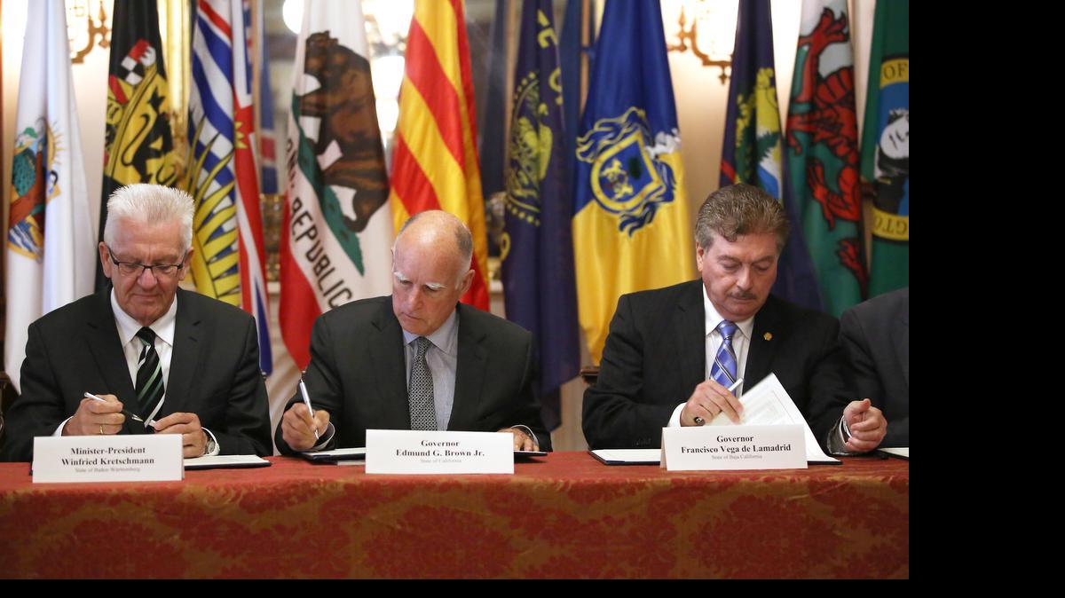 
Gov. Jerry Brown, center, flanked by Baden-Wurttemberg Minister-President Winfried Kretschmann, left, of Germany, and Baja California Gov. Francisco A. Vega de Lamadrid, join others in signing a non-binding climate change agreement in Sacramento, Calif., Tuesday, May 19, 2015. The memorandum of understanding calls for limiting the increase of global warming average to below 2 degrees Celsius.
