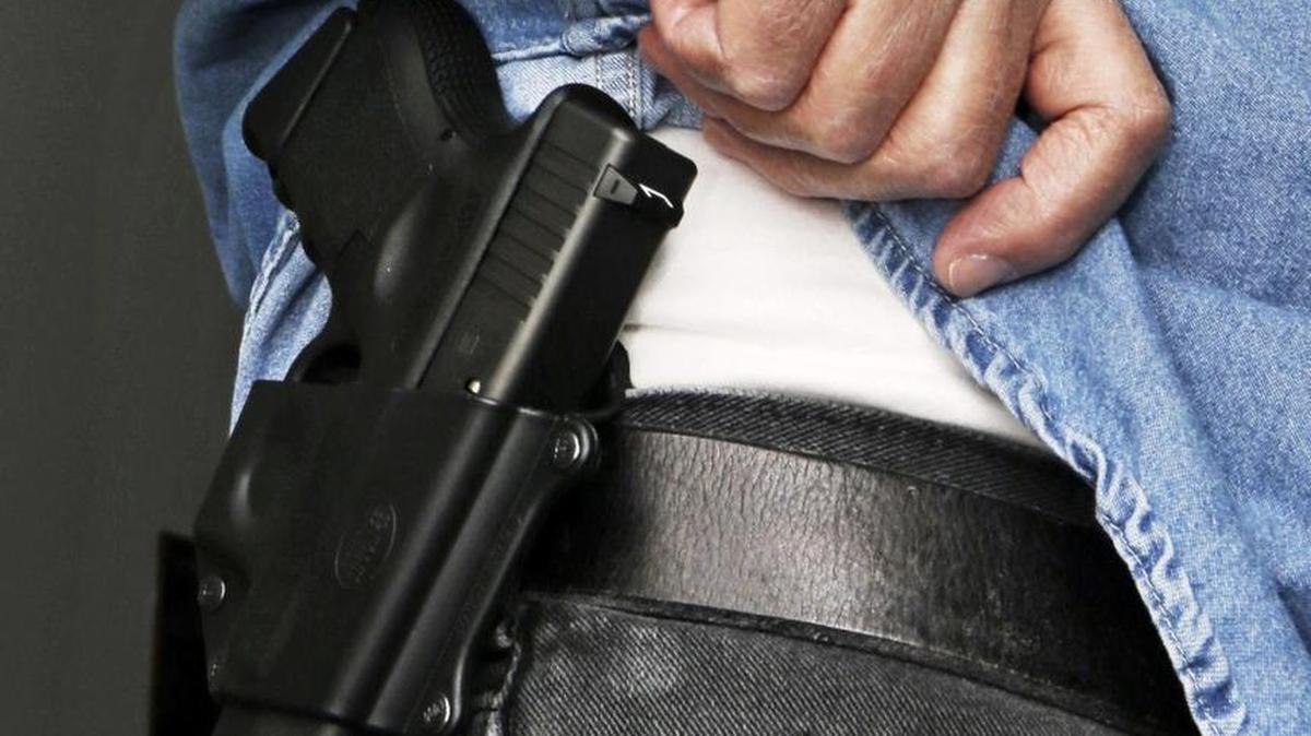 An Ohio gun owner displays his concealed weapon in 2013. The California Assembly on Tuesday approved legislation that would allow local governments to charge more for concealed weapons permits.