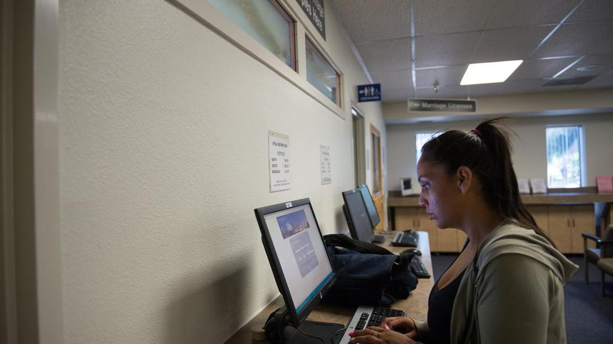 Davida Gomez applies for birth certificates at the Sacramento County Clerk-Recorder’s Office last month. Paper for such documents is in short supply in California.