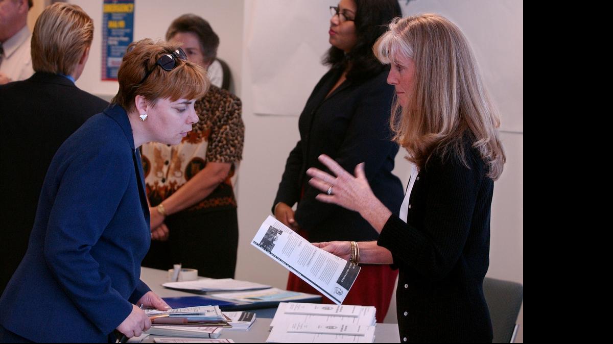 
A Department of Real Estate employee (right) talks to a job seeker during a job fair in Roseville.
