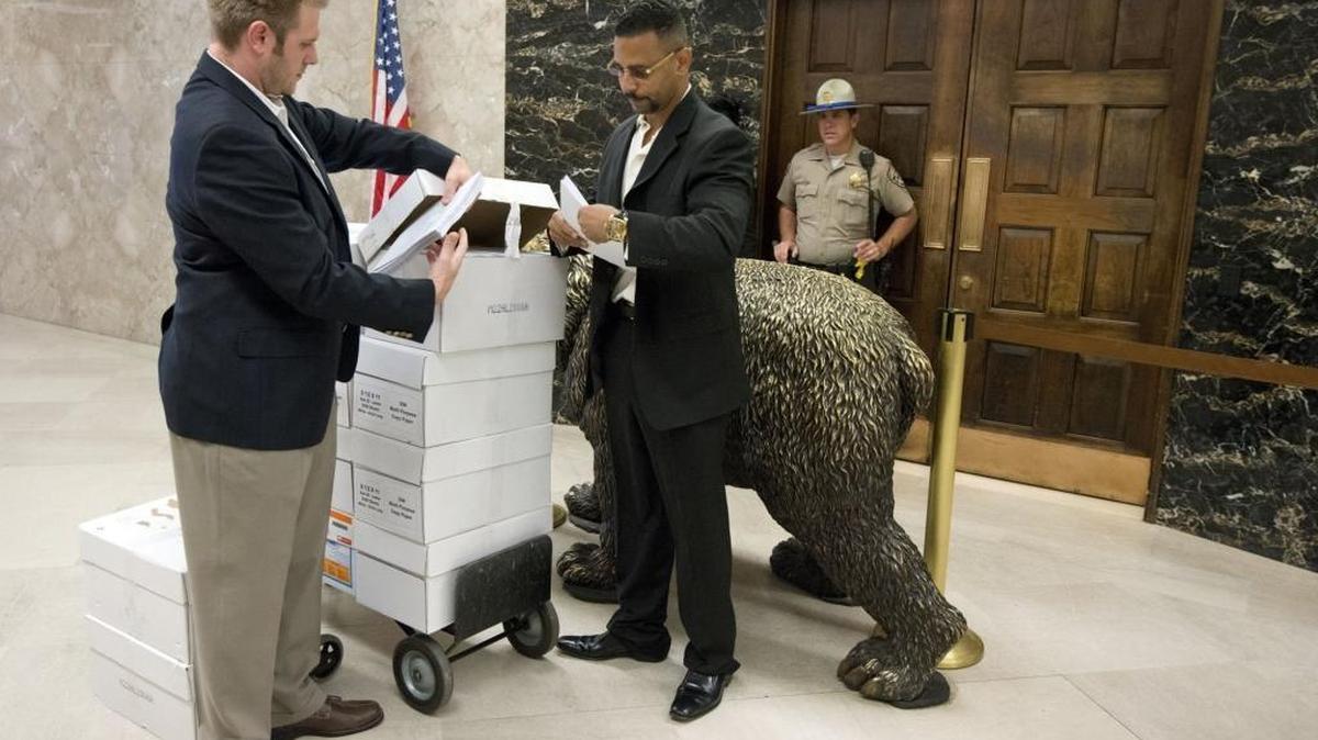 Brandon Combs, left, of the Firearms Policy Coalition, and Craig DeLuz, legislative advocate with the California Association of Federal Firearms Licensees, prepare to deliver a handful of the 67,000 letters urging the veto of 14 gun bills to Gov. Jerry Brown’s office on Oct. 3, 2013.