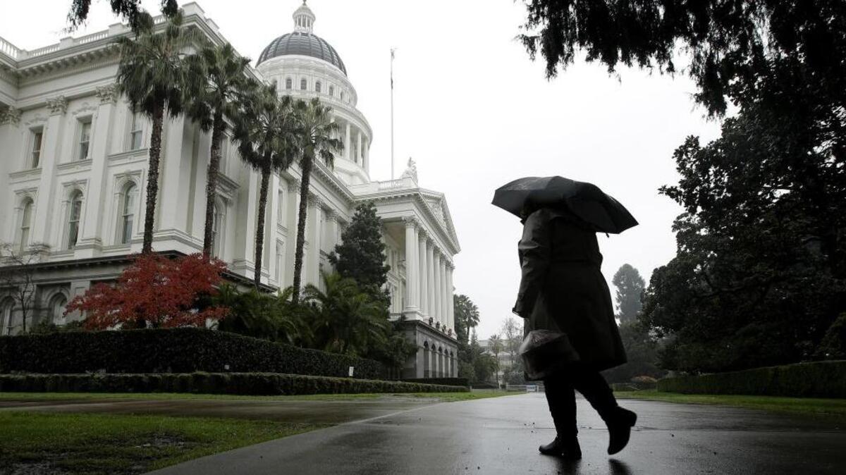 Umbrellas were put to use as a storm passes over the state Capitol in Sacramento on Dec. 8, 2016.