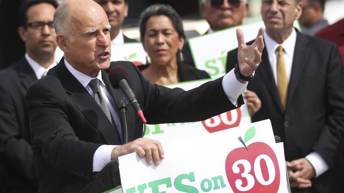 Gov. Jerry Brown makes a point in San Diego in 2012 as he holds a sign in support of Proposition 30, which temporarily increased the sales tax, as well as the income tax for high-income filers.