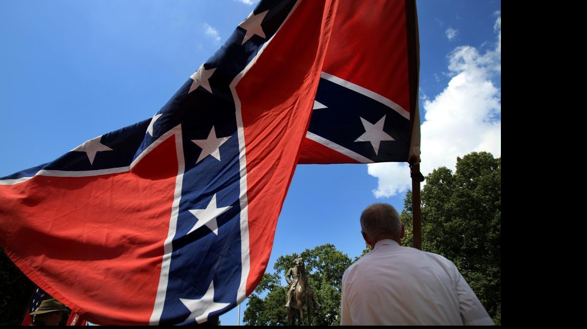 
Eddie Miller holds a Confederate flag in front of the statue and tomb of Nathan Bedford Forrest, rebel general, slave trader and early Ku Klux Klan member, during a celebration of Forrest's 194th birthday on July 13 at Health Sciences Park in Memphis, Tenn.
