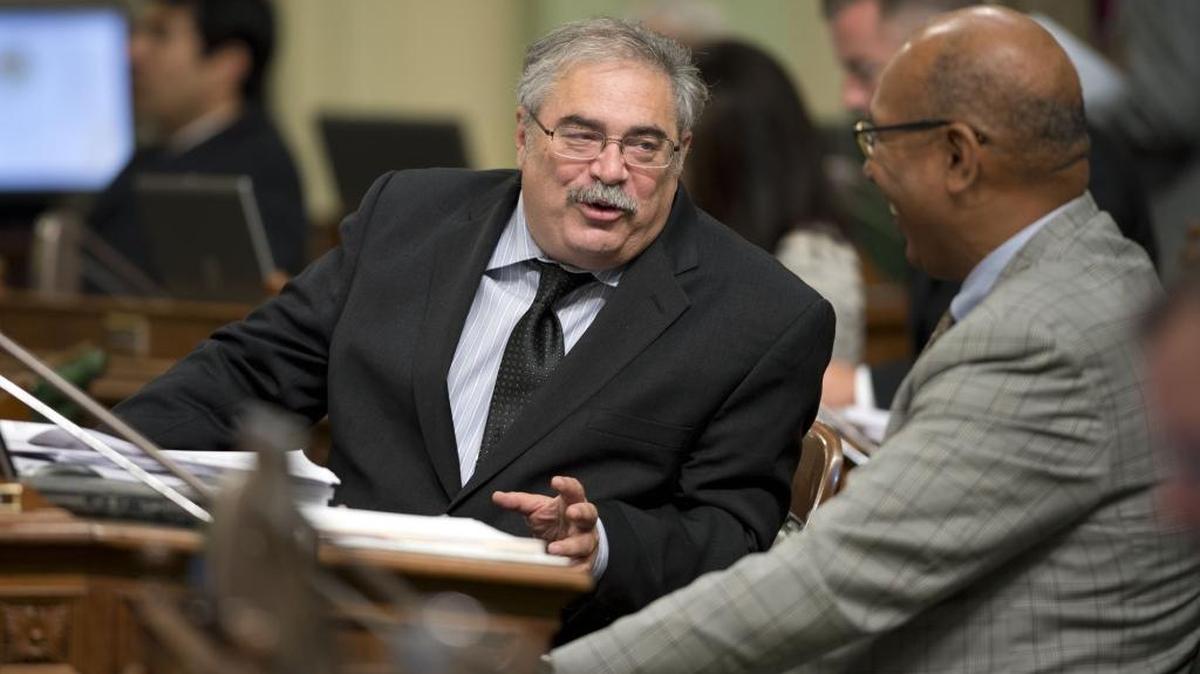 In this Aug. 20, 2014 file photo, Democratic Assemblyman Steve Fox, left, of Palmdale talks to fellow member Chris Holden, a Democrat from Pasadena during a floor session at the Capitol.