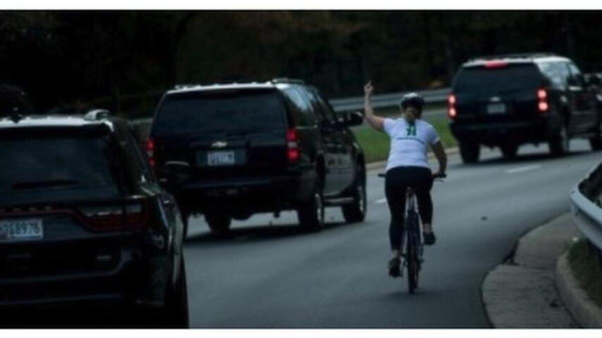 Juli Briskman gives the middle finger to President Donald Trump’s motorcade as it passes her in Sterling, Virginia.