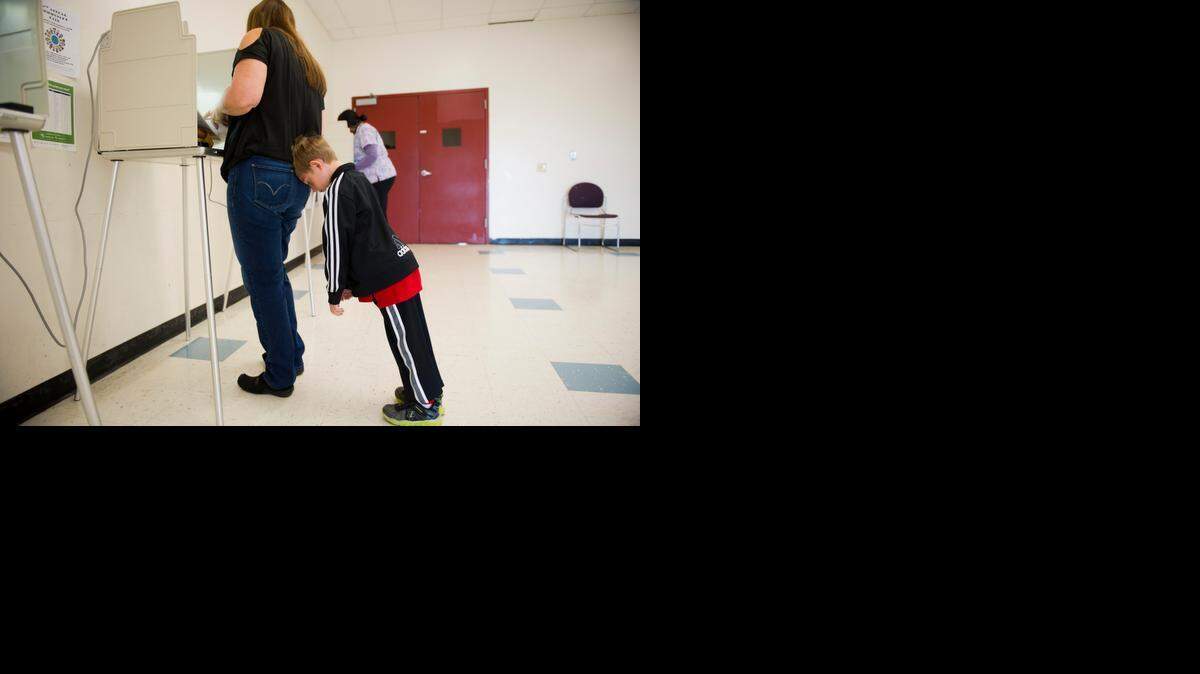 
Early morning voter Pamela Morgan casts her ballot in the statewide general election at the polling location in Natomas Pacific Pathways Prep school before taking her son Jacob Morgan, 7, to school on Tuesday, Nov. 4, 2014.
