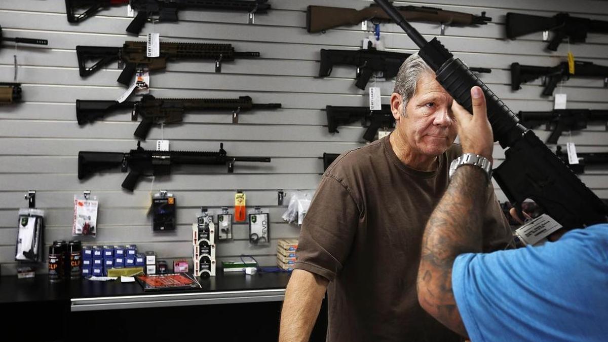 Gunsmith, Frank Cobet, of the Get Loaded gun store in Chino, Calif., shows a customer an AR-15 rifle on Tuesday, Dec. 8, 2015. Candidates for the California state Assembly and Senate hold differing views on the state’s gun laws.