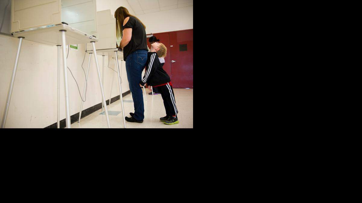 
Early-morning voter Pamela Morgan casts her ballot Nov. 4 at a polling station in Sacramento’s Natomas Pacific Pathways Prep School before taking her son Jacob, 7, to school.
