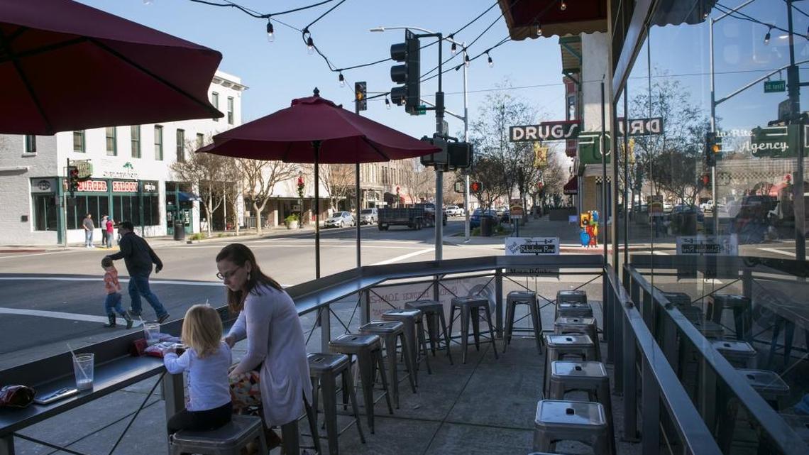 Christina Grott and her daughter, Olivia, sit at the newly opened Stack’d & Brew’d restaurant in downtown Woodland, Calif., in January. Under new election rules, two prominent Woodland leaders, Mayor Jim Hilliard and Councilman Tom Stallard, must face off to represent the downtown district.