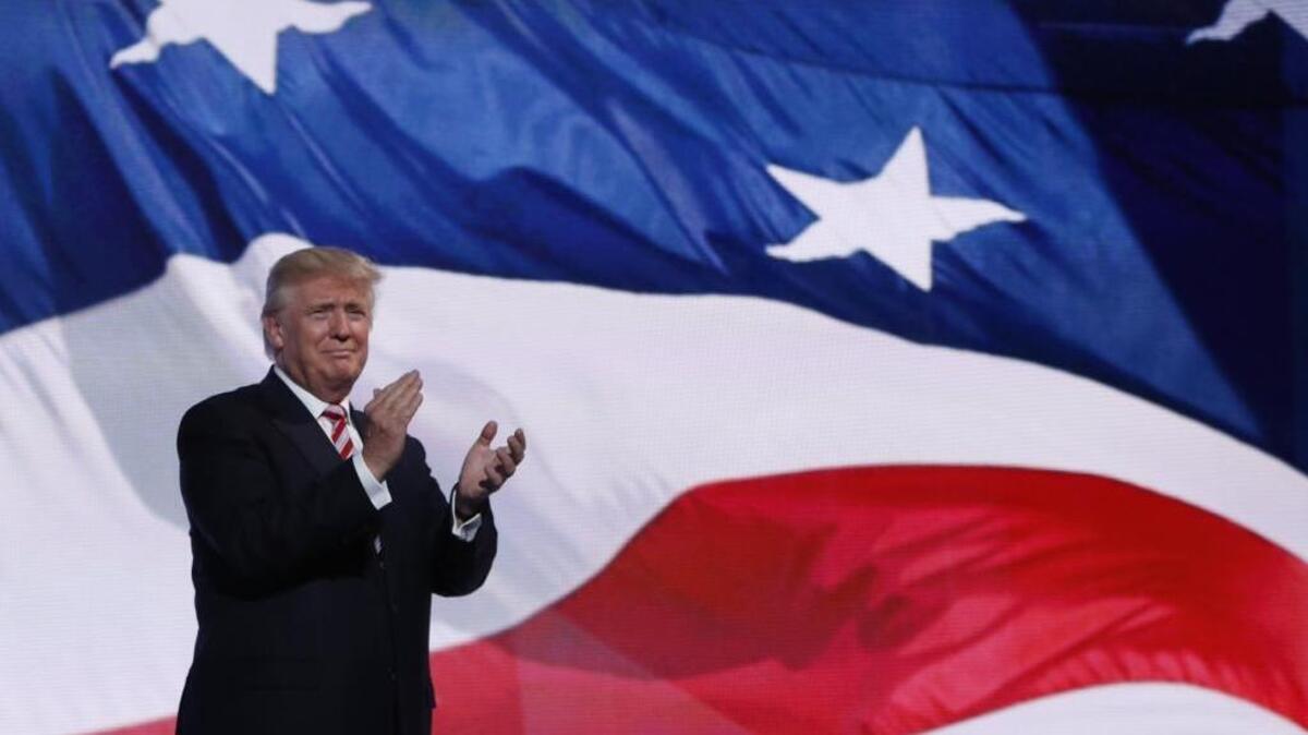 Republican presidential candidate Donald Trump walks on stage to greet his VP pick, Gov. Mike Pence of Indiana, during the third day session of the Republican National Convention in Cleveland, Wednesday, July 20, 2016.