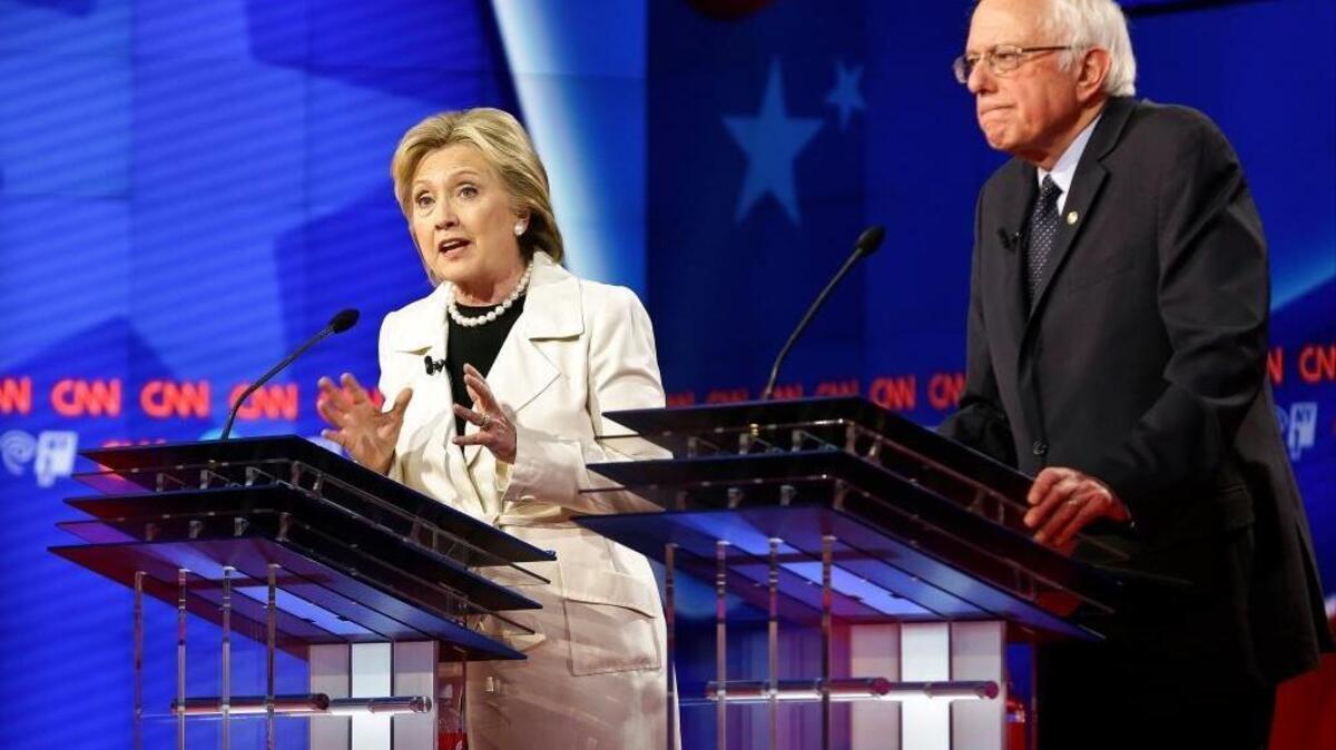 Democratic presidential candidates Sen. Bernie Sanders, I-Vt., right, listens as Hillary Clinton speaks during the CNN Democratic Presidential Primary Debate at the Brooklyn Navy Yard Thursday, April 14, 2016, New York.