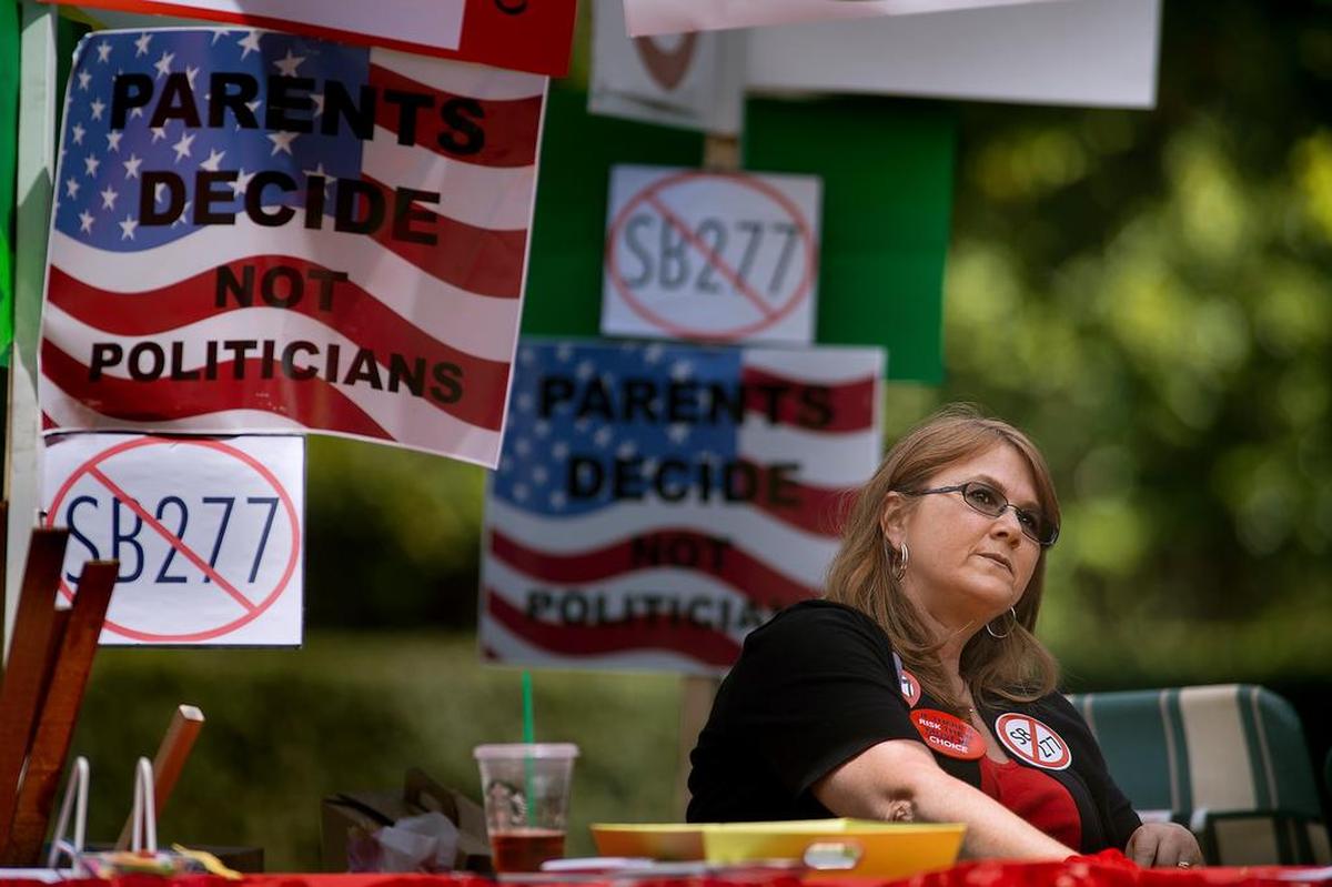 Polly Von Thaden staffs a booth Tuesday to campaign against Senate Bill 277 at the state Capitol. Von Thaden says her son suffered severe and permanent medical conditions as a result of childhood vaccinations and notes that the National Vaccine Injury Compensation fund has authorized nearly $3 billion in payments.
