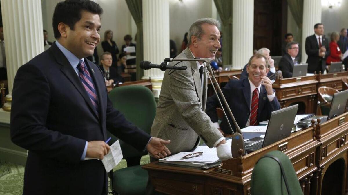 Assemblyman Jimmy Gomez, left, laughs as Assemblyman Tom Ammiano, D-San Francisco, center, jokes about problems with the Assembly’s electronic voting system in 2013. Gomez, newly elected to Congress, still has not taken his seat there.