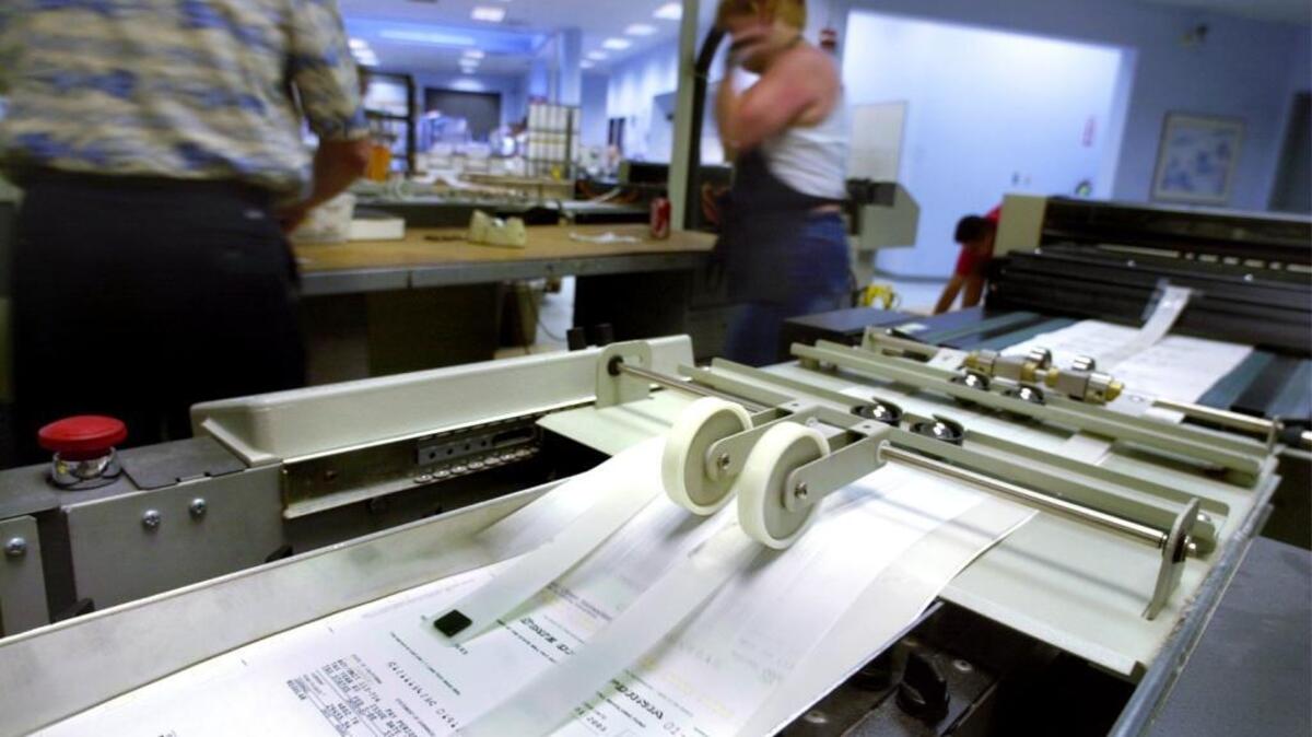 State paychecks roll of a printer at the State Controller's Office on C Street in Sacramento.
