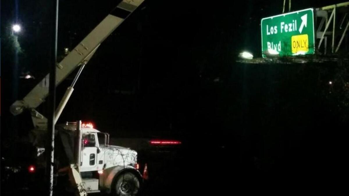 A truck removes an incorrectly-spelled freeway sign over the on-ramp to Los Feliz Boulevard on Monday. The old sign it was supposed to replace was re-installed.