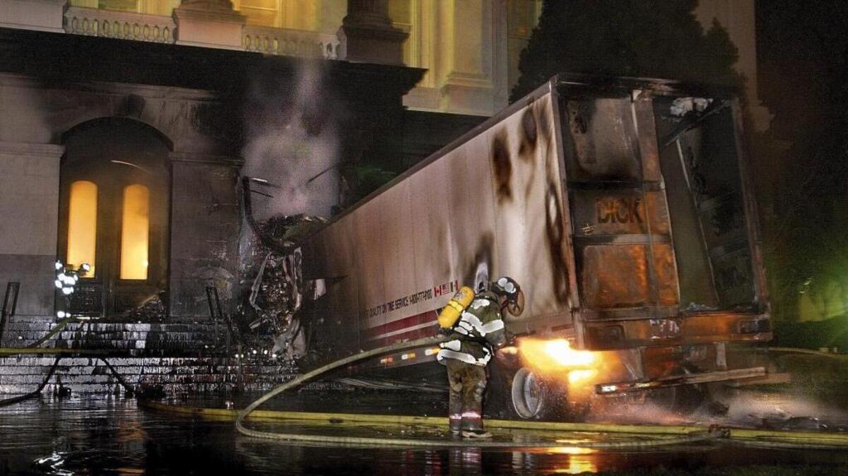 A firefighter extinguishes flames from a big rig that crashed into the south steps of the Capitol and burst into flames on Tuesday, Jan. 16, 2001. The driver was killed in the crash, which took place just as the Assembly was adjourning for the night. The crash prompted security upgrades at the Capitol.