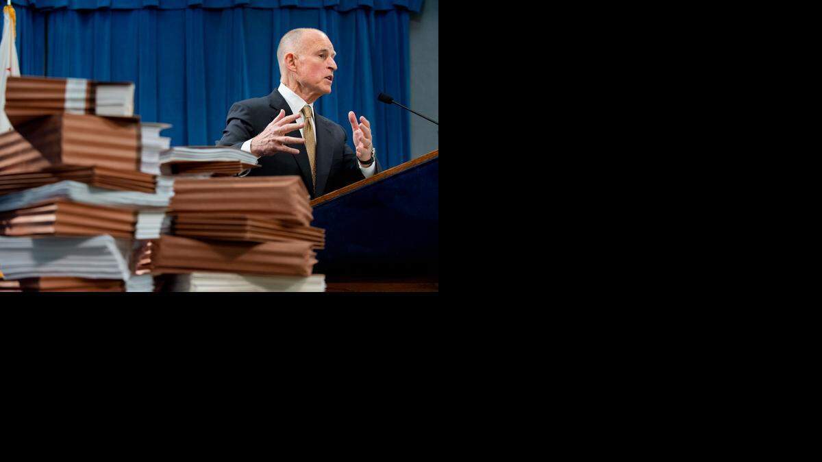 
 Gov. Jerry Brown speaks during a 2013 news conference, saying the state was taking legal action to end a federal court order that capped the state's prison population.
