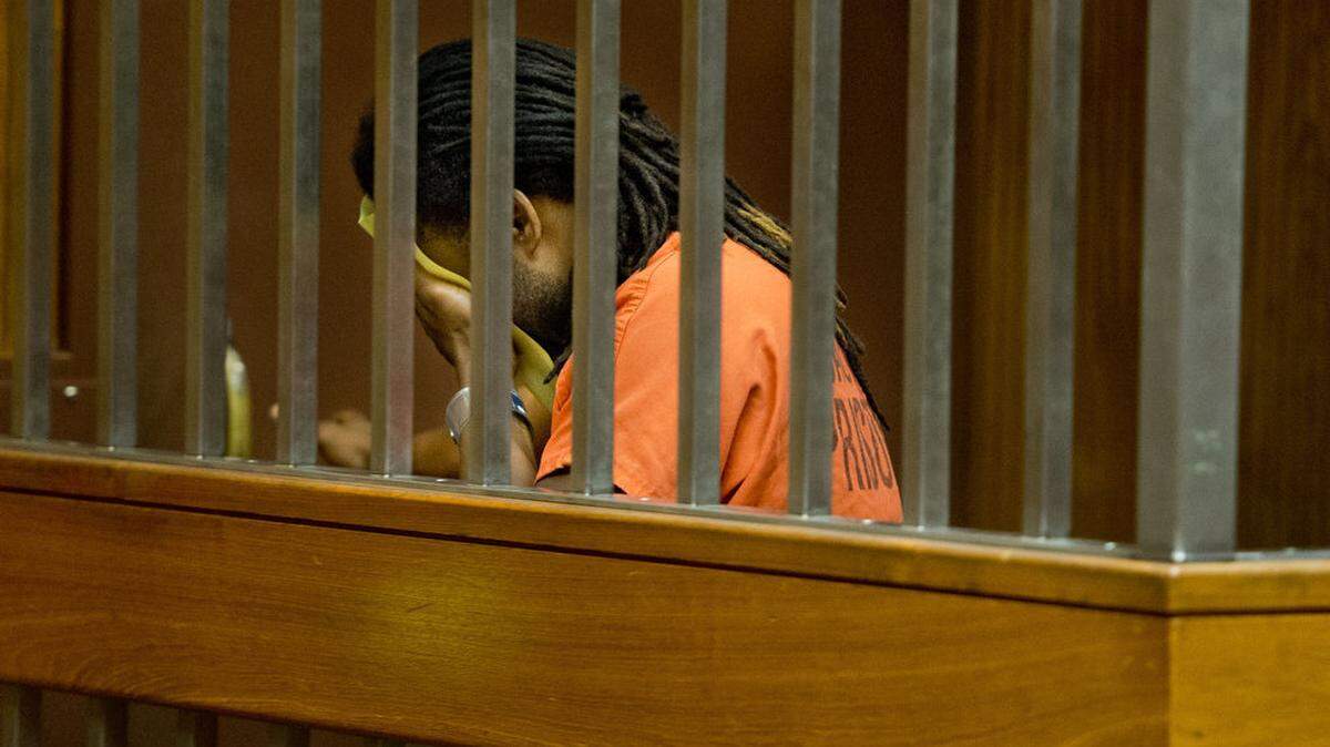 Murder suspect Dameshlo Green covers his face after his first appearance in court  in 2014. Green, 38, also was found guilty Tuesday of being a felon in possession of a firearm and using a firearm in the shooting death of 31-year-old Tamisha Evette Ridge.